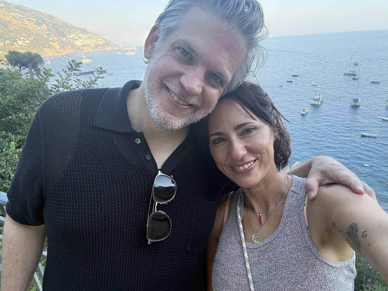 Danielle and Patrick on a cliffside above the Amalfi Coast at golden hour
