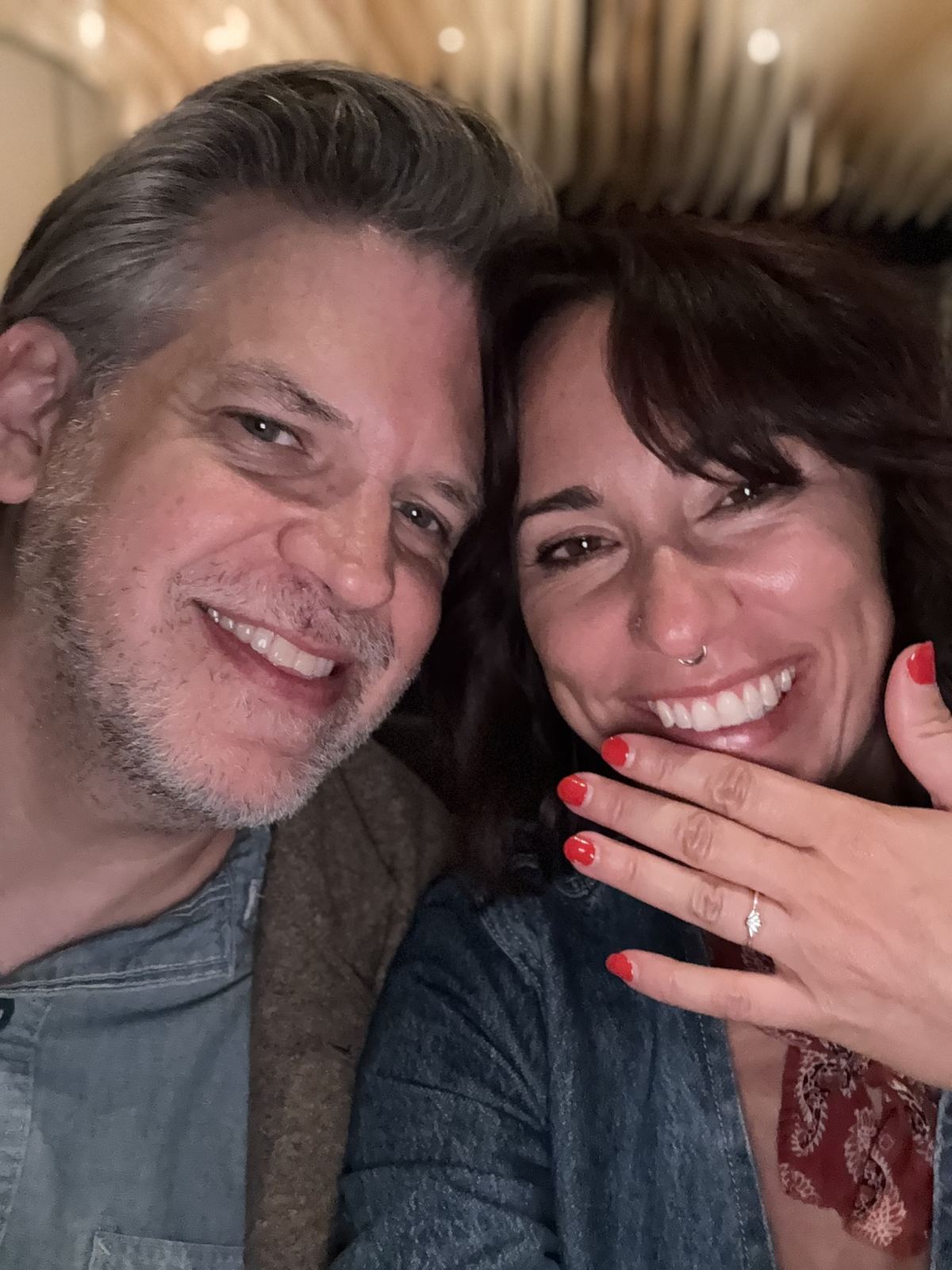 Close-up of Danielle showing her engagement ring, laughing with Patrick